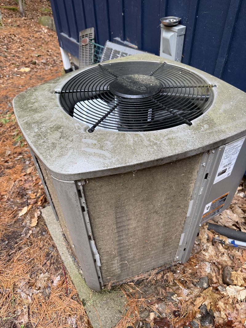 Outdoor A/C condenser with its coil fins clogged with dirt and grime