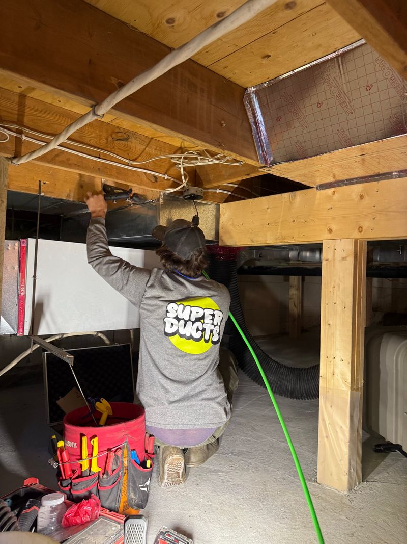 Super Ducts technician cleaning basement ductwork